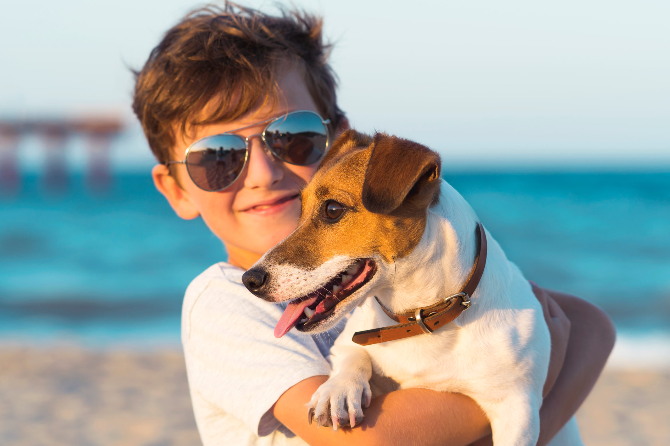 boy enjoying a vacation at Folly Beach with his dog.
