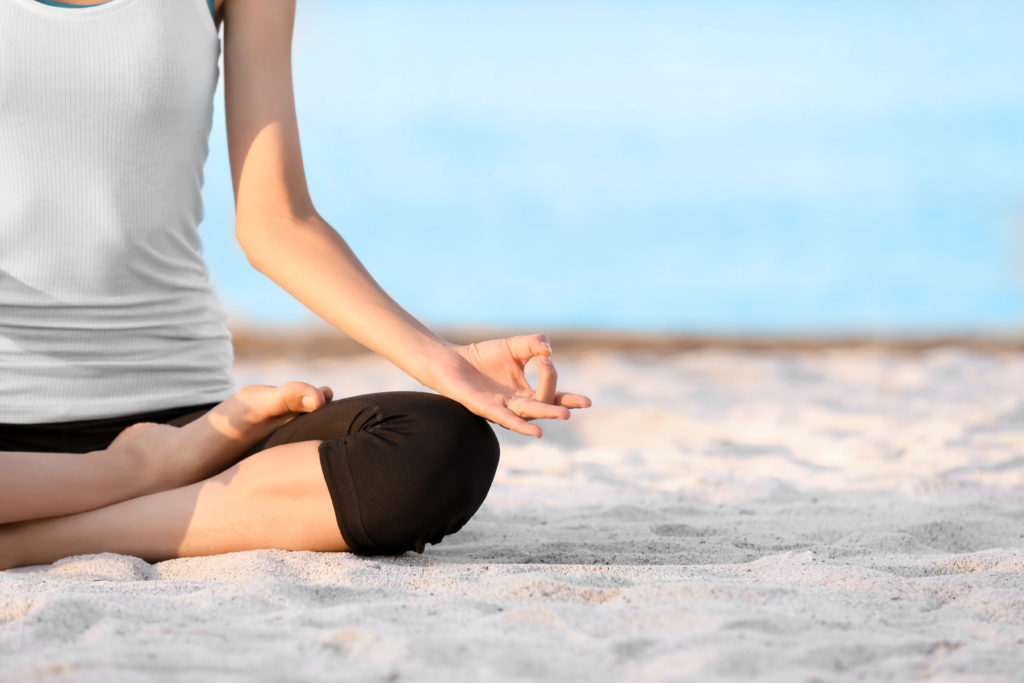 woman doing yoga at sunrise on Folly Beach SC