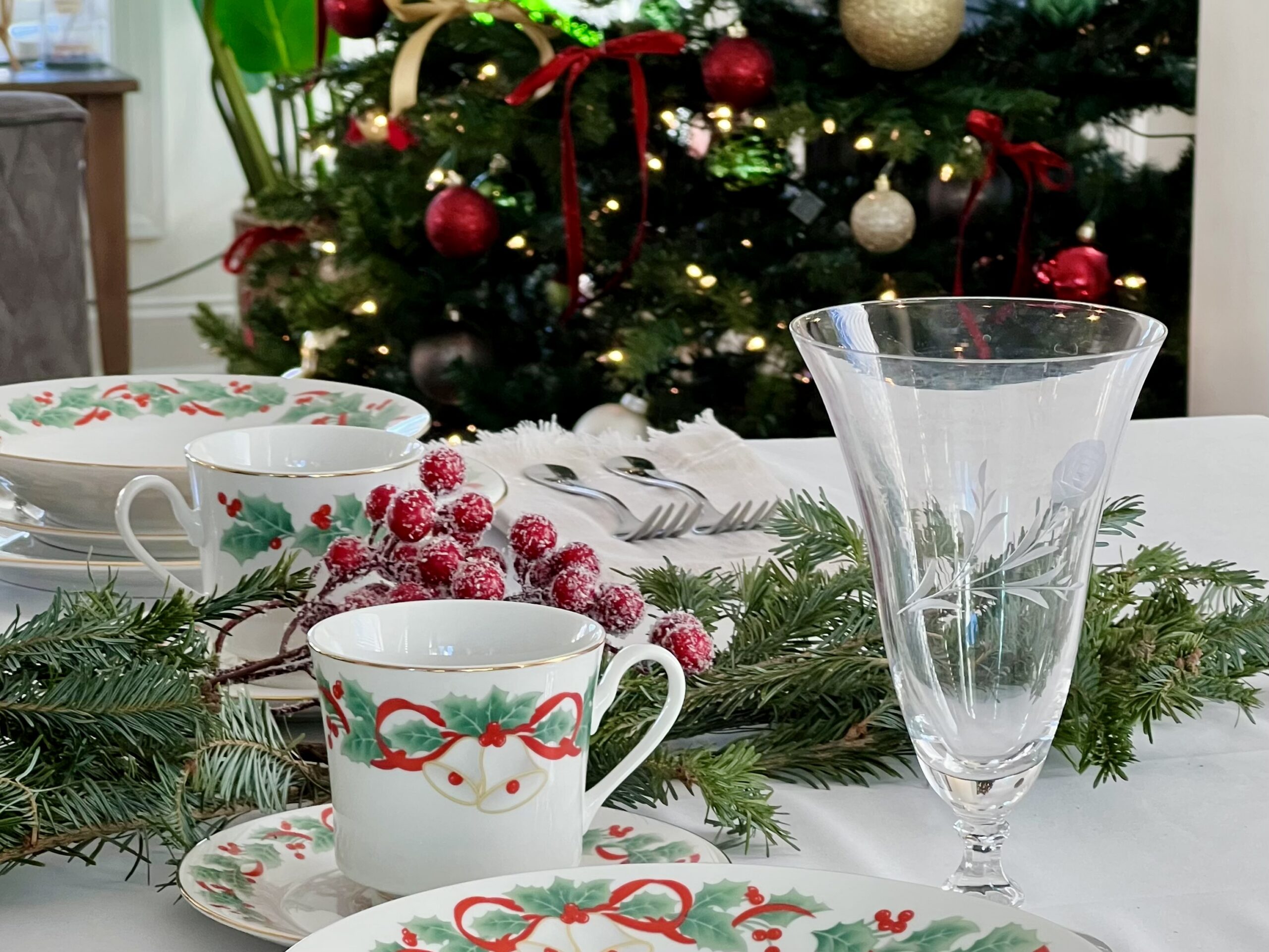 a beautiful table set with christmas dishes and ready for a christmas dinner to be served
